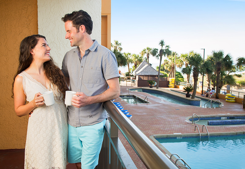 Couple on the balcony at The Caravelle Resort Myrtle Beach. 